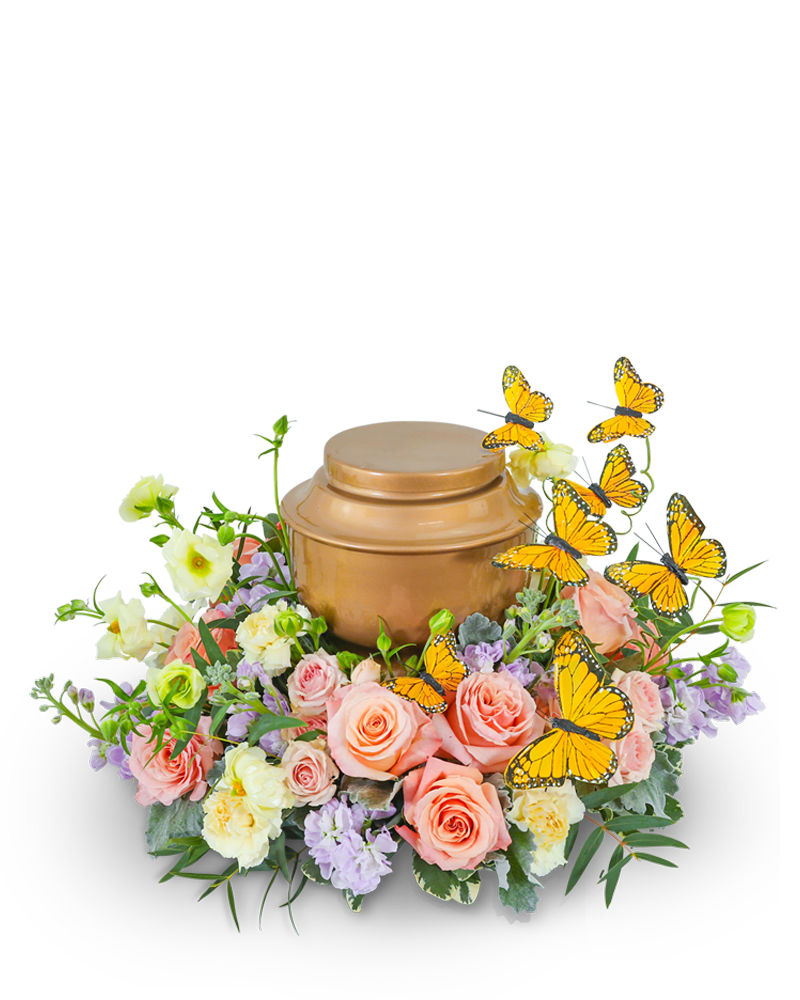 Peach and lavender floral arrangement around a bronze urn with butterfly picks