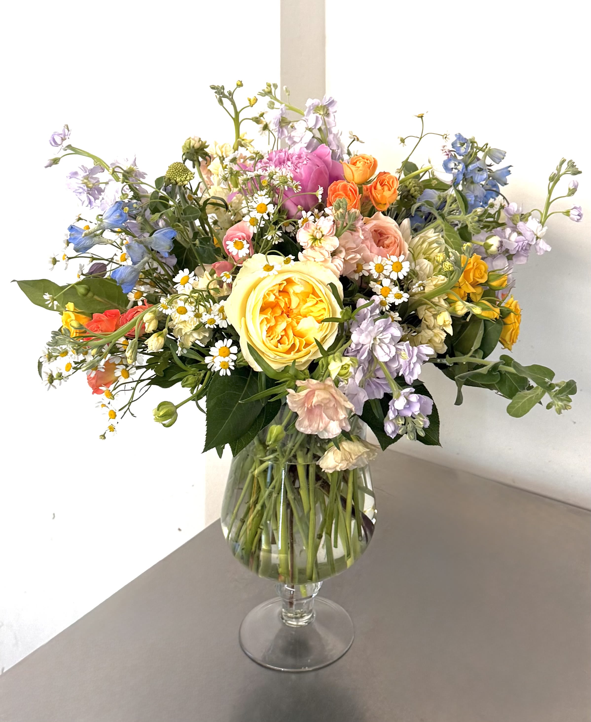 Sunshine &amp; Wildflowers Garden Bouquet - This vibrant and cheerful arrangement is a "Sunshine &amp; Wildflowers" Garden Bouquet. It features a lush, "low and lush" design style that emphasizes texture and a diverse, sunny color palette.
