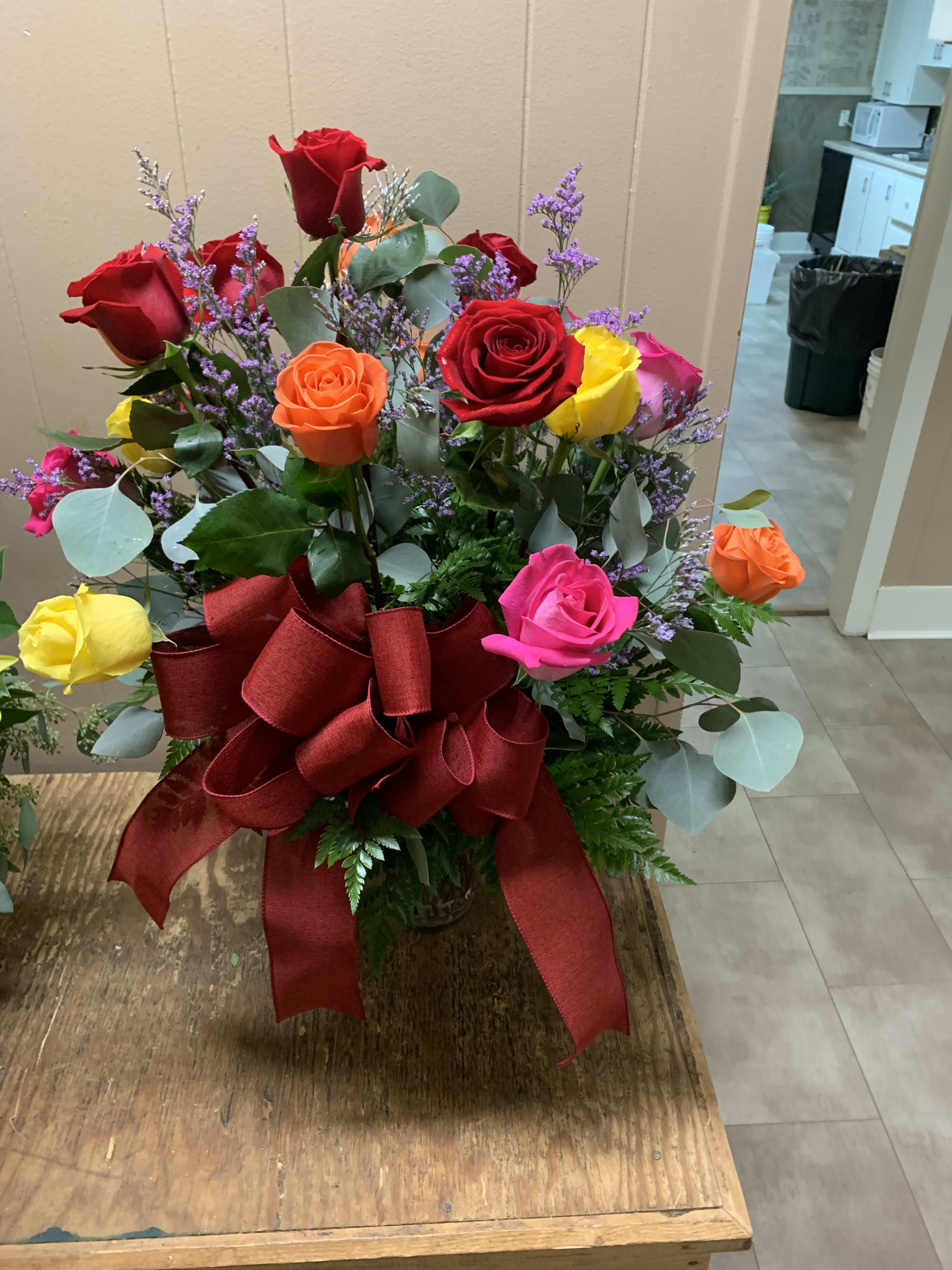 Mixed roses in a vase with a large red ribbon bow