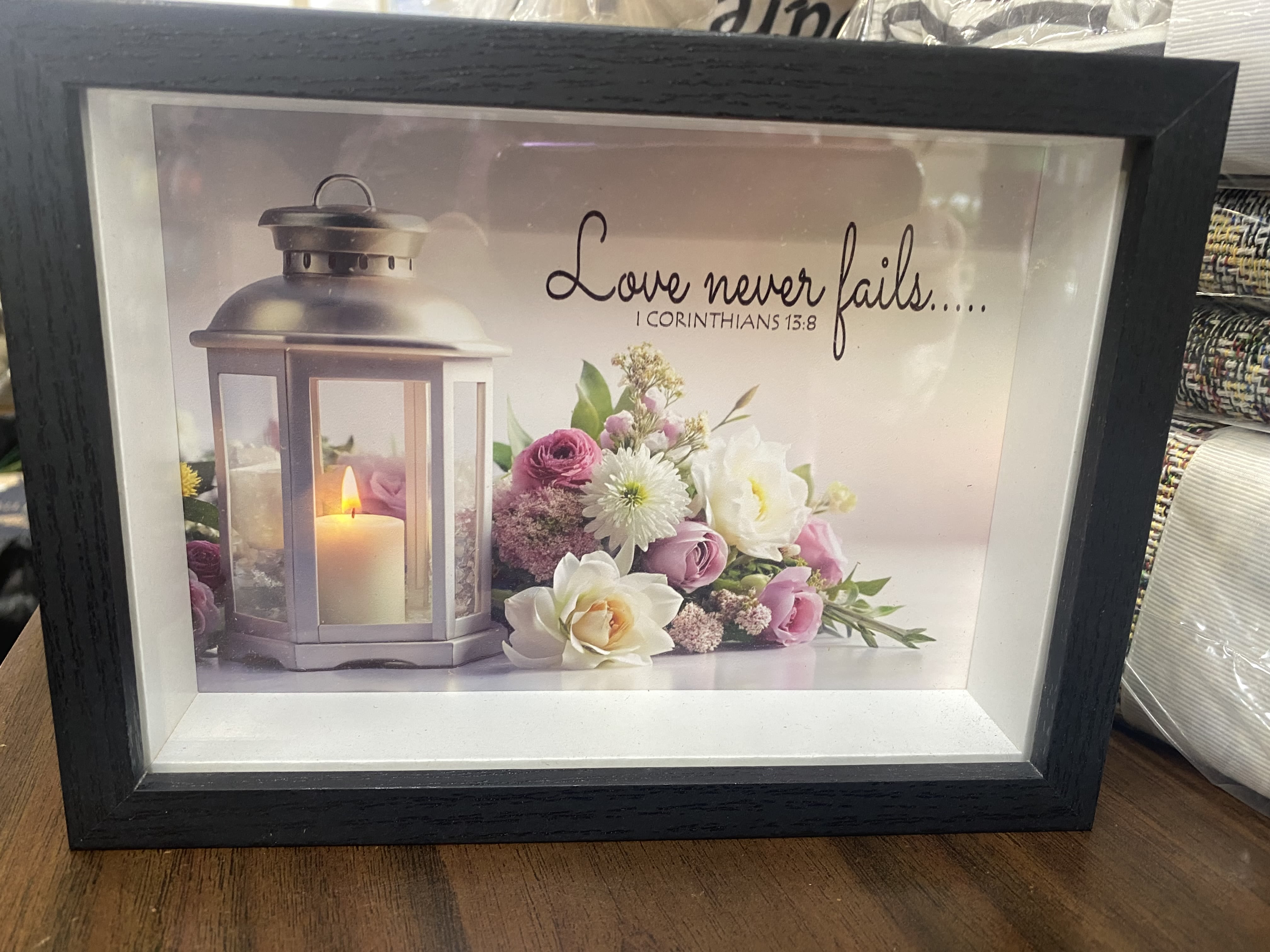 Framed candle and pink-white floral print with a Bible verse