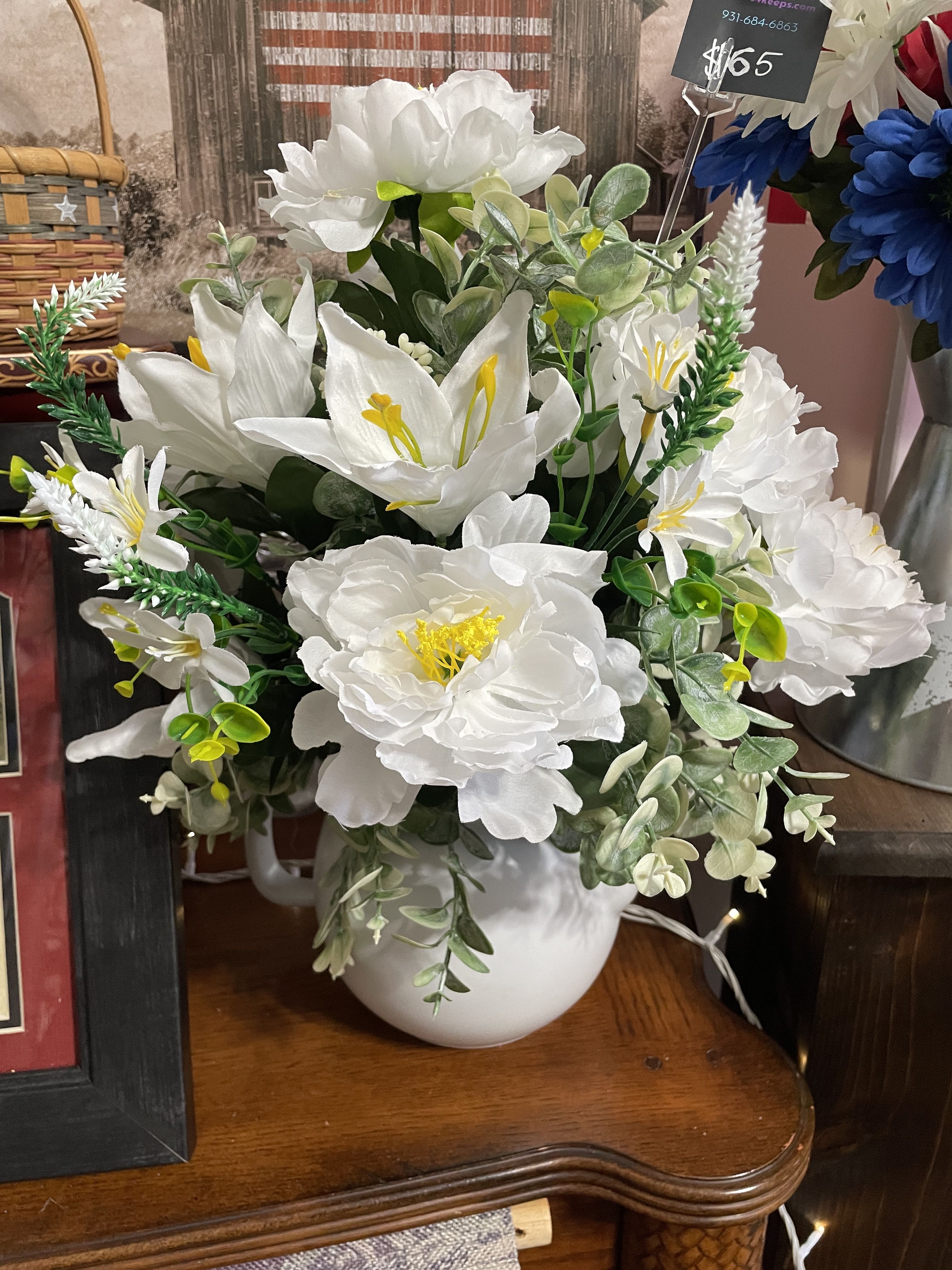 White floral arrangement in a white pitcher vase