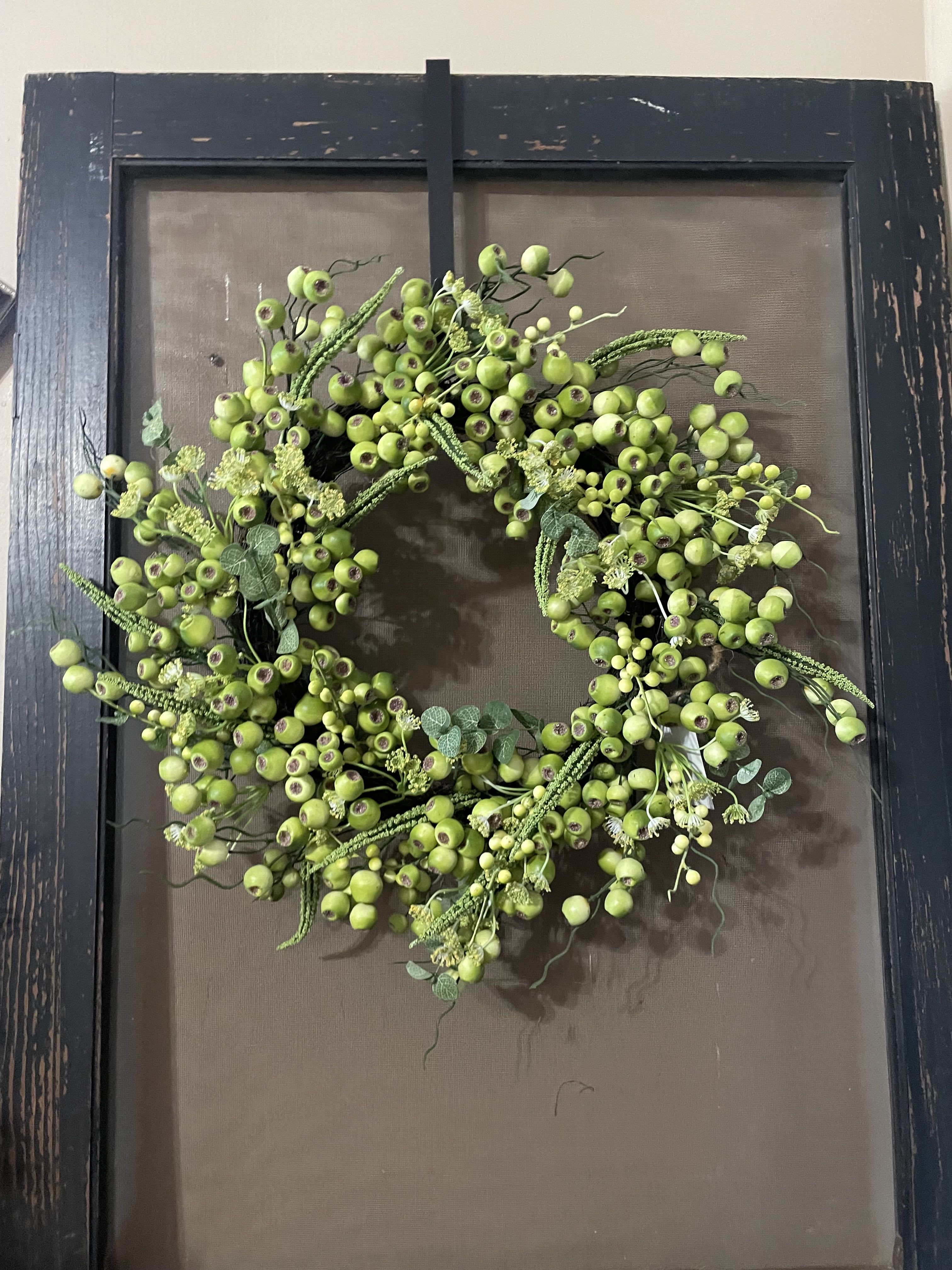 Green berry wreath on a dark framed background