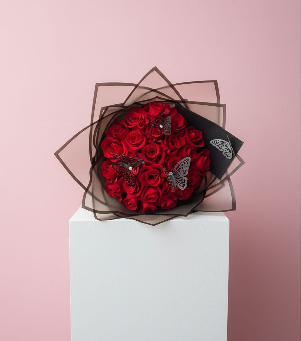 Bouquet of red roses wrapped in black paper with butterfly accents