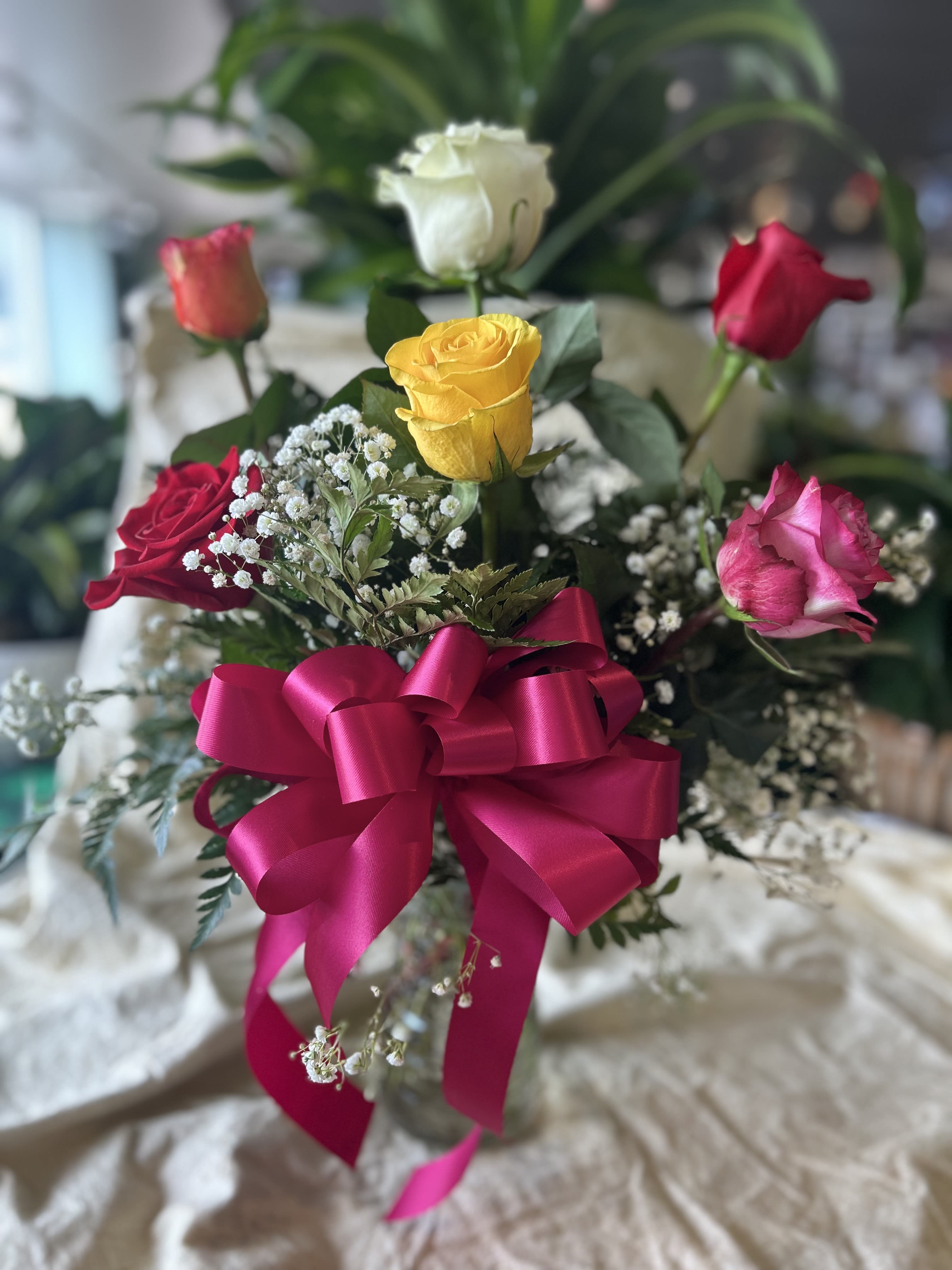 Bouquet of multicolored roses with a pink ribbon bow