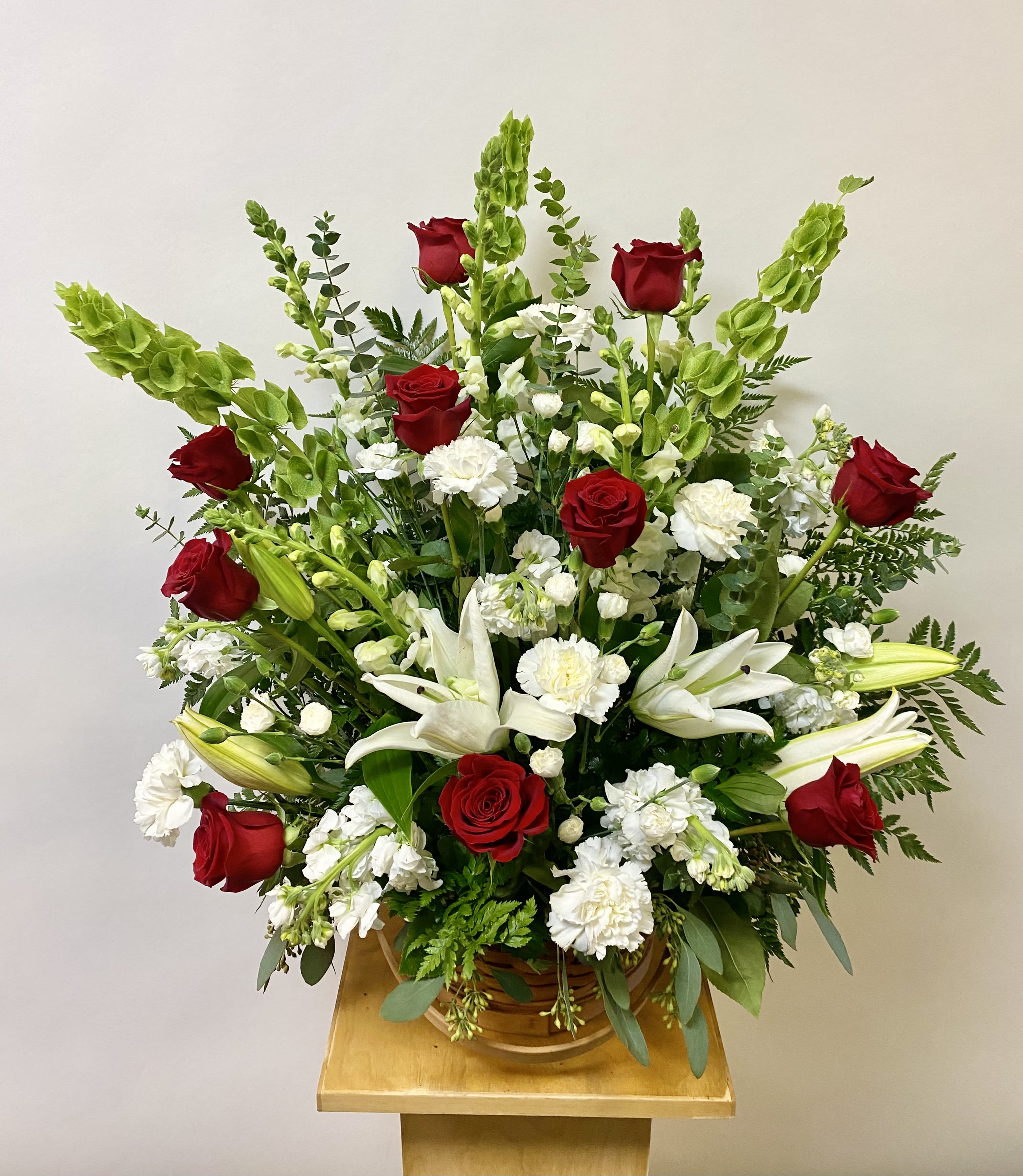 Red roses and white lilies in a basket arrangement