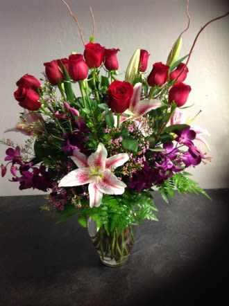 Red roses and pink lilies in a clear glass vase