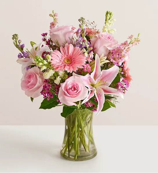 Pink mixed bouquet with roses and lilies in a clear glass vase