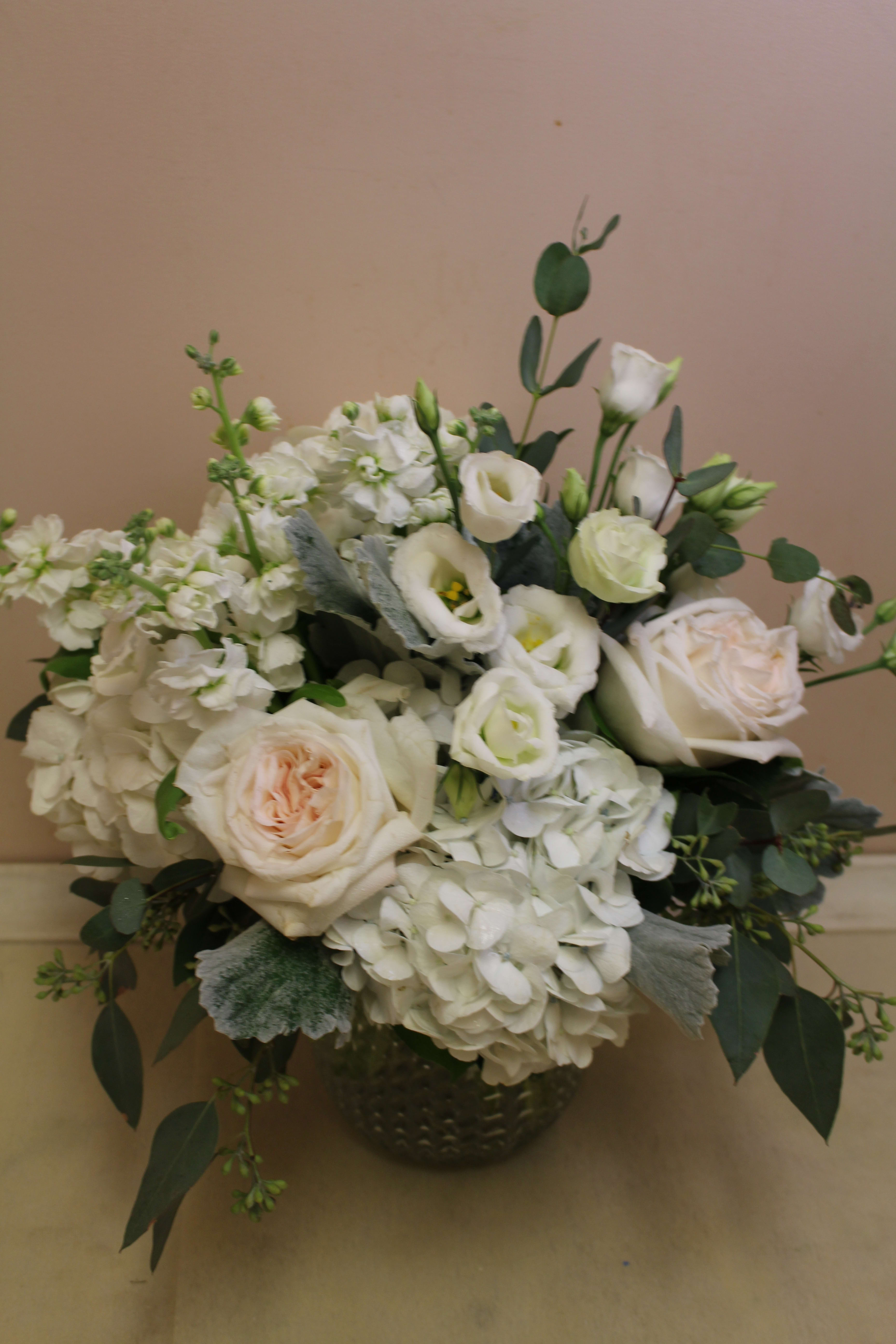 White roses and hydrangeas in a dark vase
