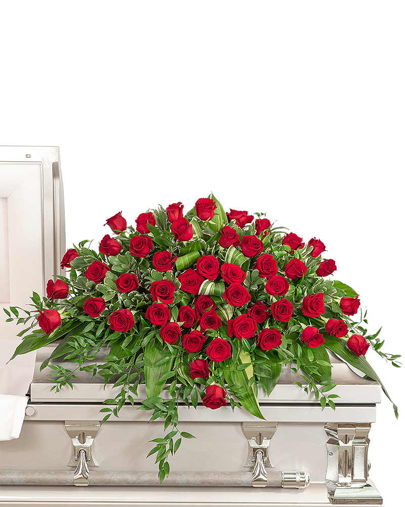 Large red rose casket spray on a light-colored casket