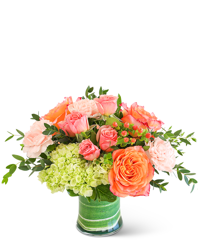 Coral Calma - Citrus Garden will bring a burst of vibrant energy with its exquisite combination of hot pink, orange, and green hues. This stunning floral arrangement, set in a clear vase, features a blend of Roses, Green Trick Dianthus, Hydrangea, and Hypericum Berry, accented with premium foliage. It makes the perfect birthday or get-well gift, with its cheerful charm.