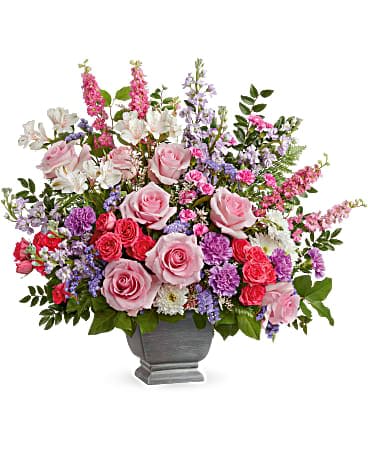 Mixed pink and purple floral arrangement in a gray urn vase