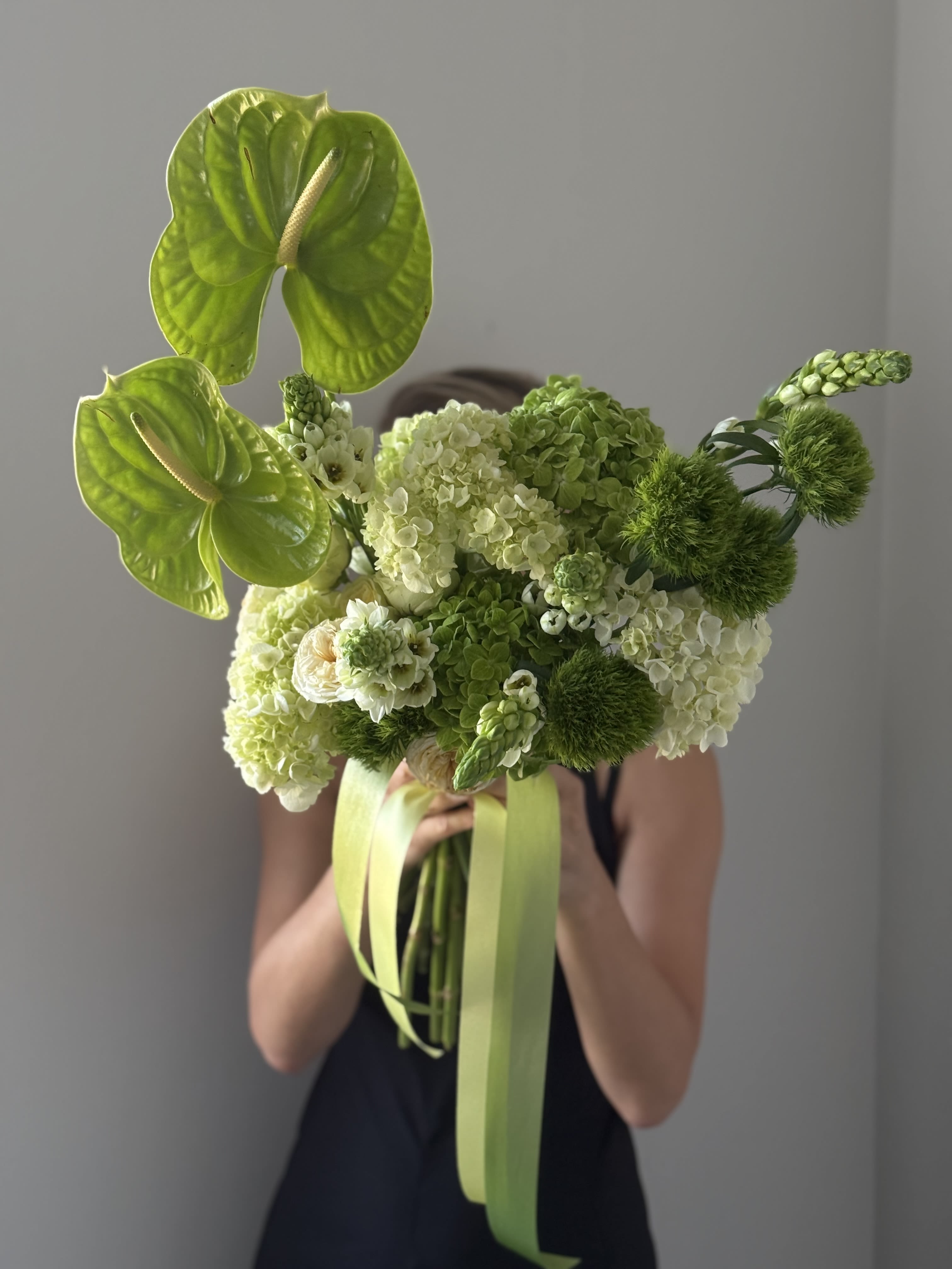 Bouquet of green anthuriums and hydrangeas with ribbon