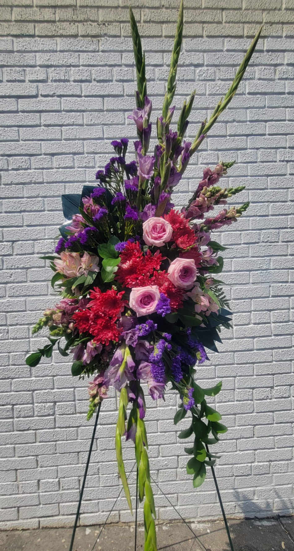spray standing colorful #1 - it is made with: 3 pink roses 3 red pompoms 8 purple stock 5 pink stock 5 pink alstromeria 5 purple statice greens