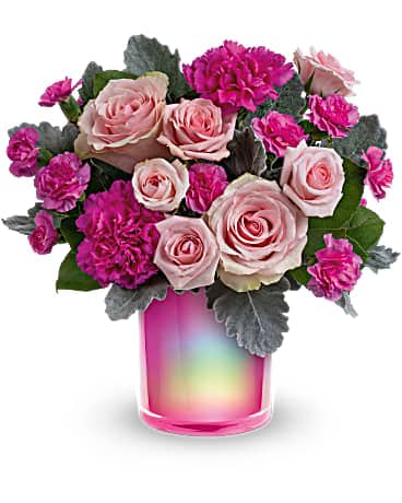 Pink roses and magenta carnations in a pink glass vase