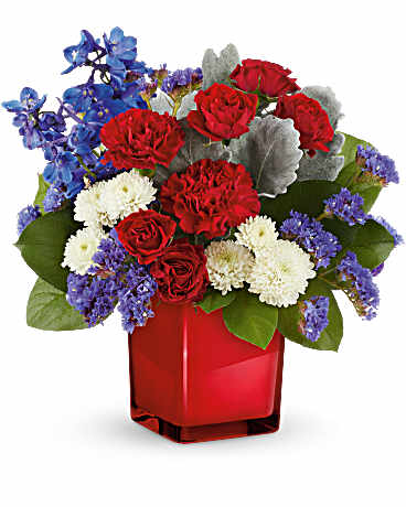 Red roses, white carnations, and blue flowers in a red vase