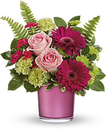 Pink roses and magenta gerberas in a pink glass vase