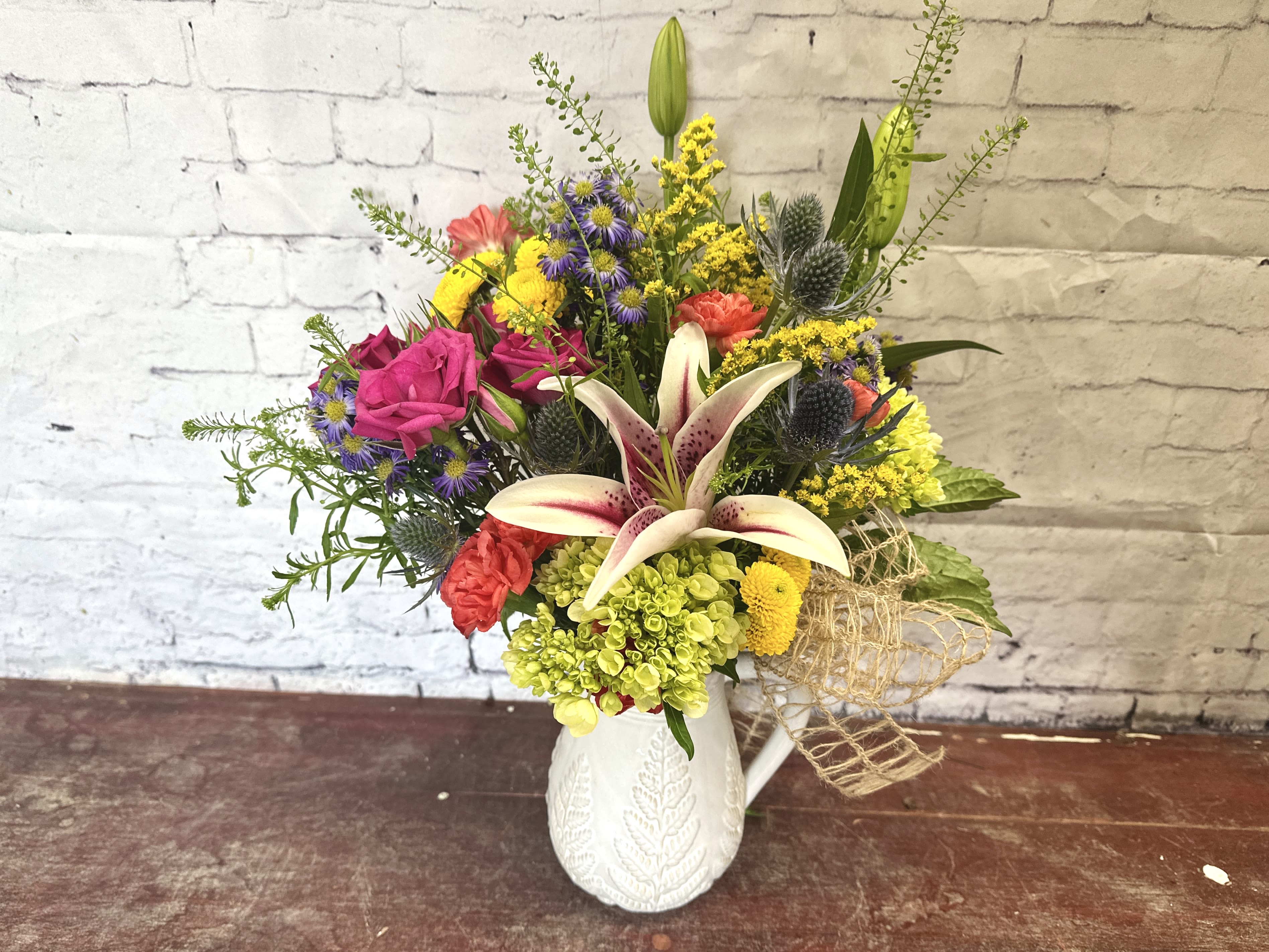 Garden party pitcher - Small white pitcher with a bright garden-style mix in premium florals: lilies, roses, hydrangeas, and other wild flowers 