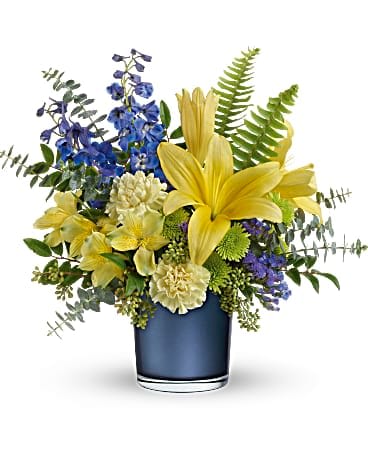 Yellow lilies and blue flowers arranged in a blue vase
