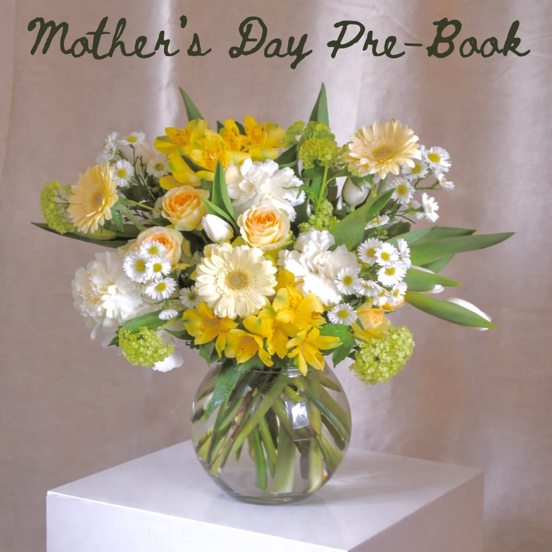 Spring Meadows 1 - A bright and buttery yellow garden-style arrangement featuring spray roses, aster, alstroemeria, viburnum, and daisies. Designed in a clear glass vase with visible stems, it has an airy, freshly gathered feel—sunny and bright.