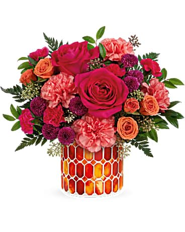 Bouquet of pink and orange roses in a patterned glass vase