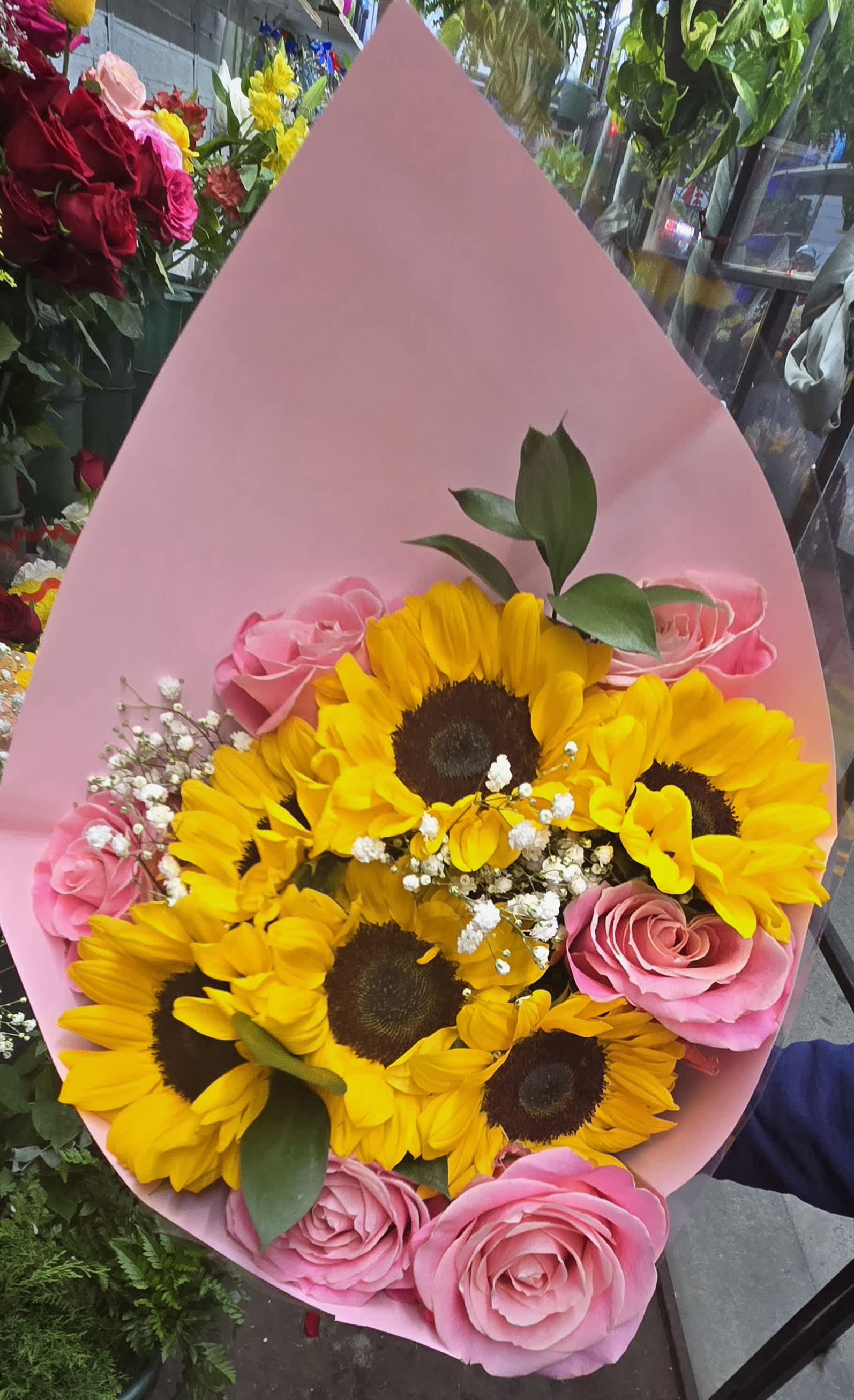 Bouquet of yellow sunflowers and pink roses wrapped in pink paper