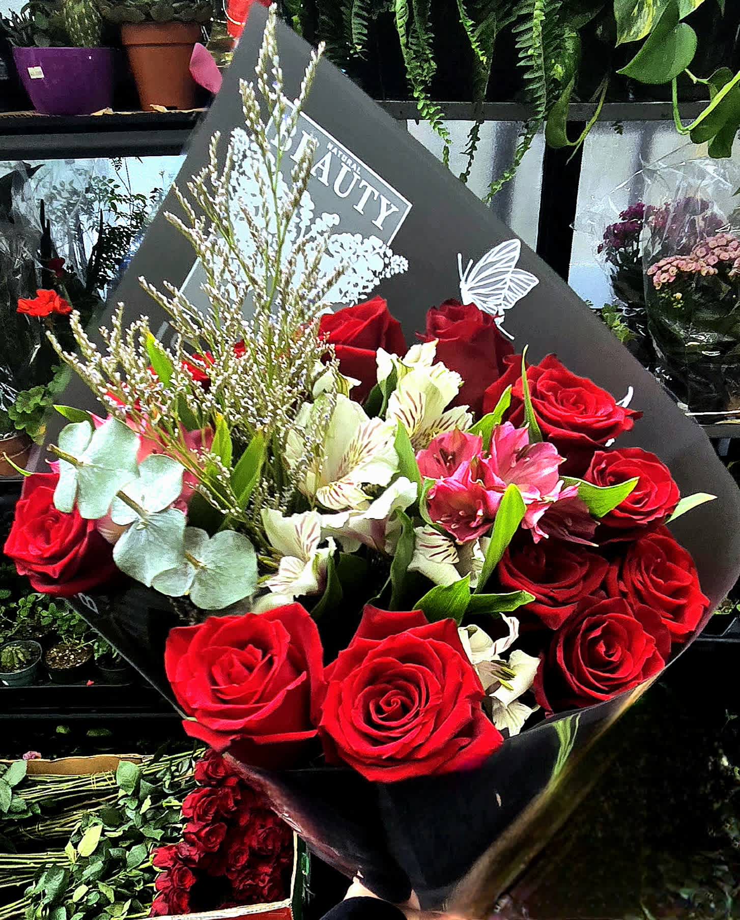Bouquet of red roses and white alstroemeria in black wrap