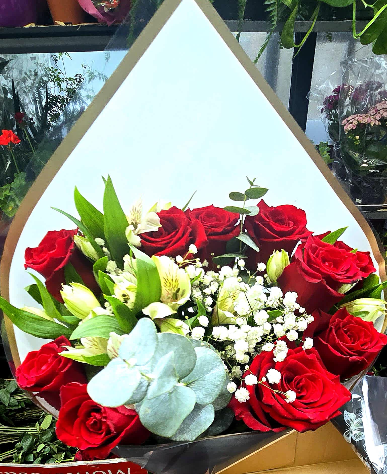 Bouquet of red roses with white alstroemeria in white wrap