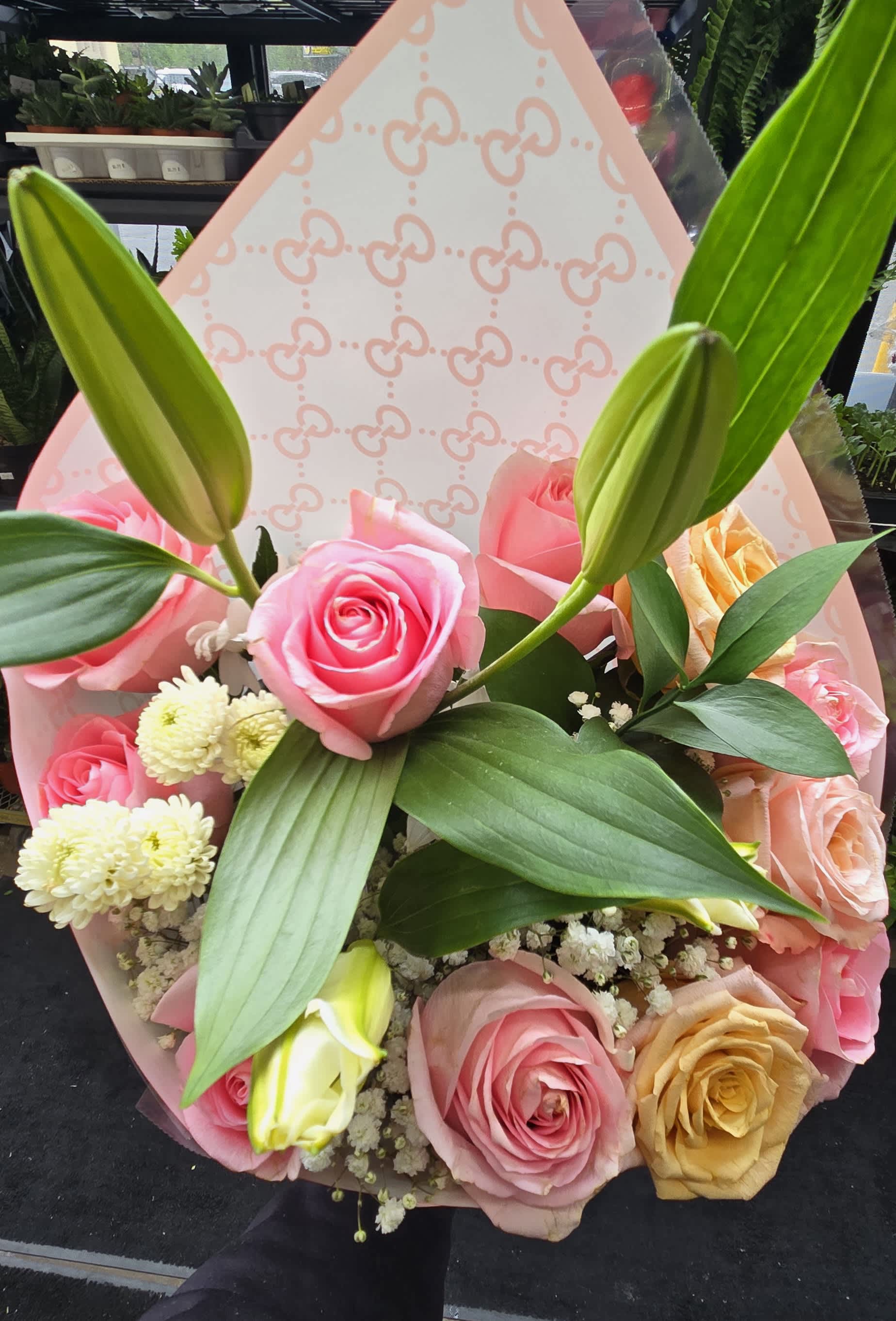 Pink and peach rose bouquet with lily buds and white filler flowers