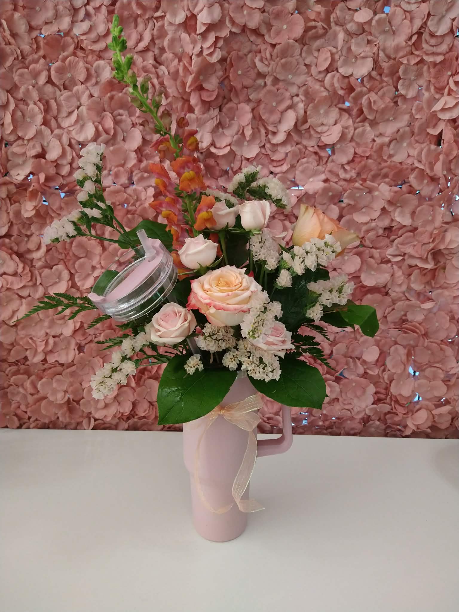 Mother's Day Tumbler Peach - An assortment of peach and pink florals in a sturdy tumbler with a lid and straw.
