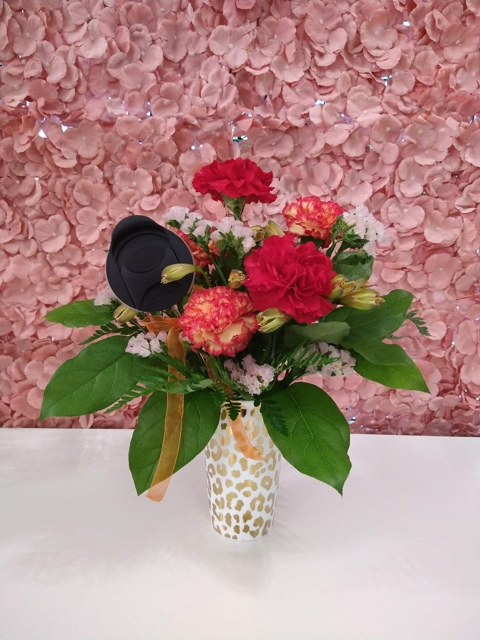 Mother's Day Tumbler Gold - An assortment of red and orange florals in a sturdy gold cheetah print tumbler with a lid.