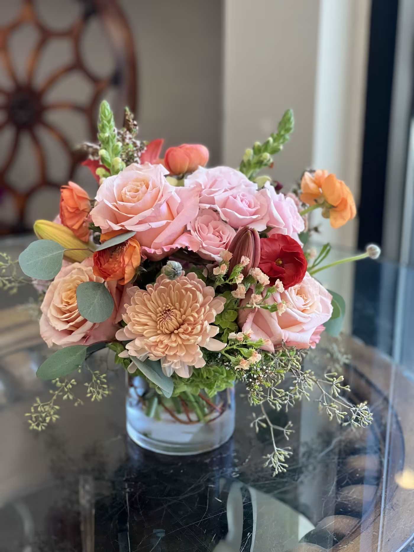 Pink and peach flower arrangement in a clear glass vase