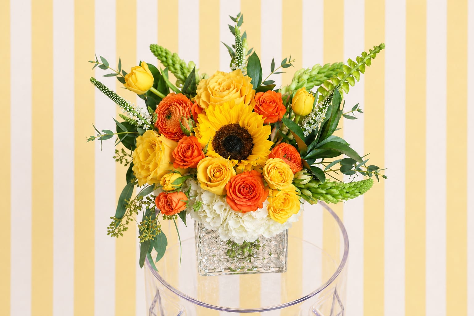Golden Sunshine Garden – Mother’s Day Flowers | DFW Florist - Bright, happy, and full of life—our Golden Sunshine Garden is designed for the mom who loves cheerful yellows, warm oranges, and sunny vibes.  Inspired by the arrangement shown, this design features a radiant color palette and a lush, rounded shape that makes a statement. A sunflower or similar focal bloom may be included when available to enhance the sunny feel.  As always, we use premium, fresh flowers and design each arrangement to match the color palette, size, and overall style, while allowing for natural variation based on seasonal availability.   Best for: Yellow, orange, and bright color lovers  Style: Bold, cheerful, and eye-catching  Delivery: Same-day options available in DFW
