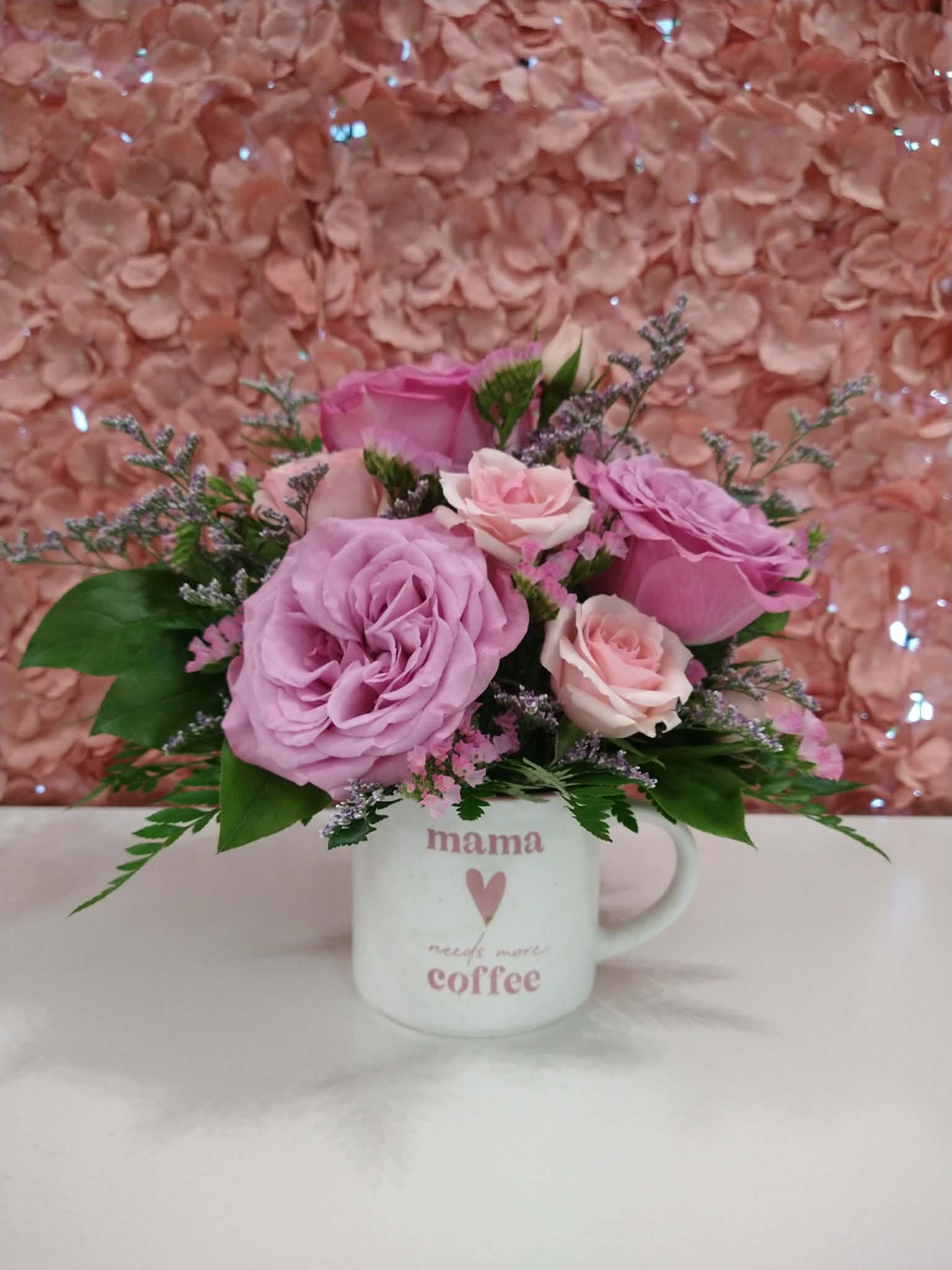 Mother's Day Coffee Mug - Assorted florals in a white and pink ceramic mug that says "Mama needs more coffee".