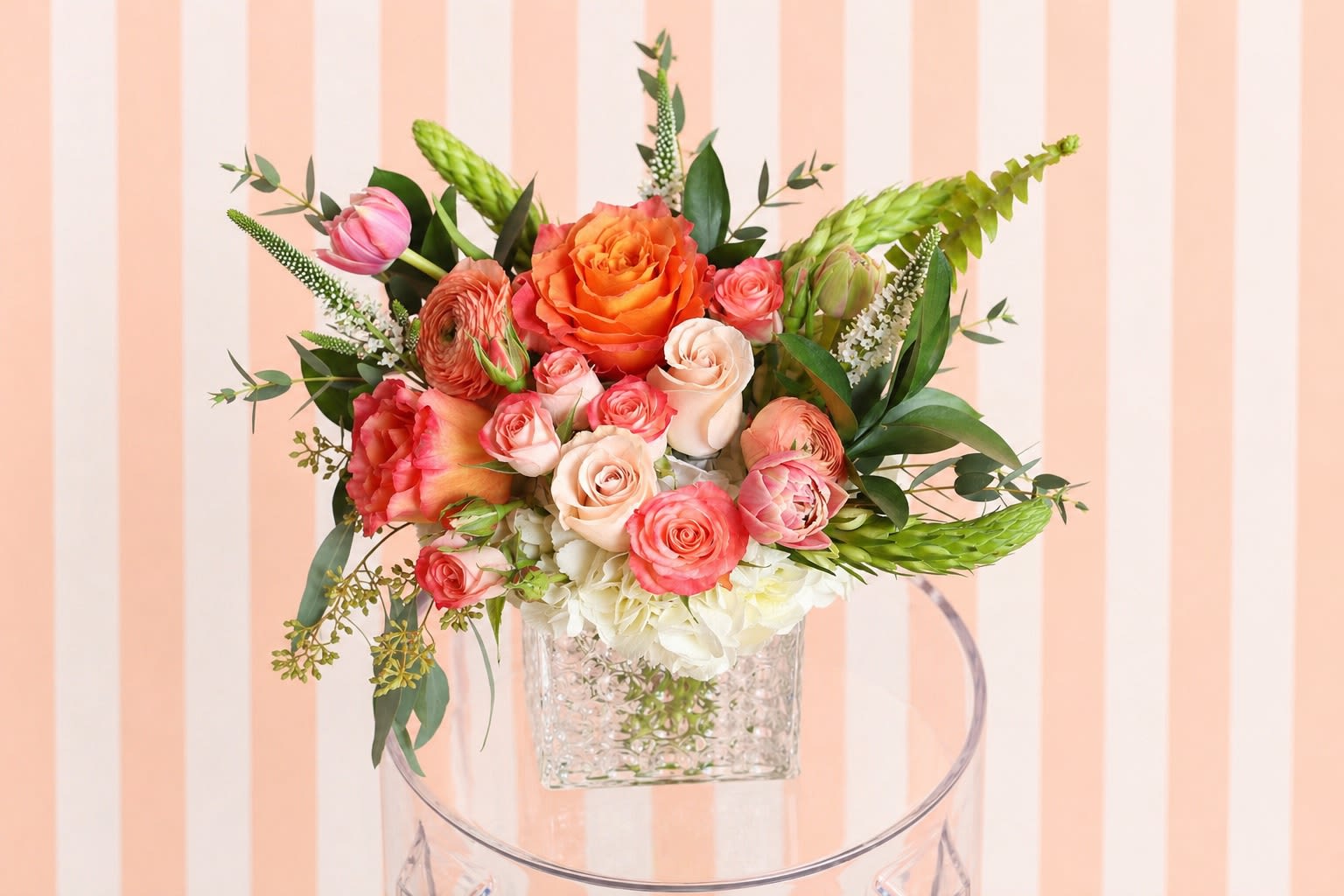 Peach &amp; Coral Garden – Mother’s Day Arrangement | DFW Florist - Celebrate her with soft, romantic tones in our Peach &amp; Coral Garden—a fresh, garden-style Mother’s Day arrangement designed in warm peach, coral, and blush hues.  This design is perfect if she loves soft, feminine colors with a fresh spring feel. Our designers will create an arrangement inspired by this look using premium, seasonal blooms in the same color palette and overall size.  Each arrangement is artistically designed and one-of-a-kind, so exact flowers may vary based on the freshest stems available—but the color story, fullness, and elevated style will always be honored.   Best for: Peach, coral, blush lovers  Style: Soft, airy, garden-inspired  Delivery: Available across Dallas–Fort Worth