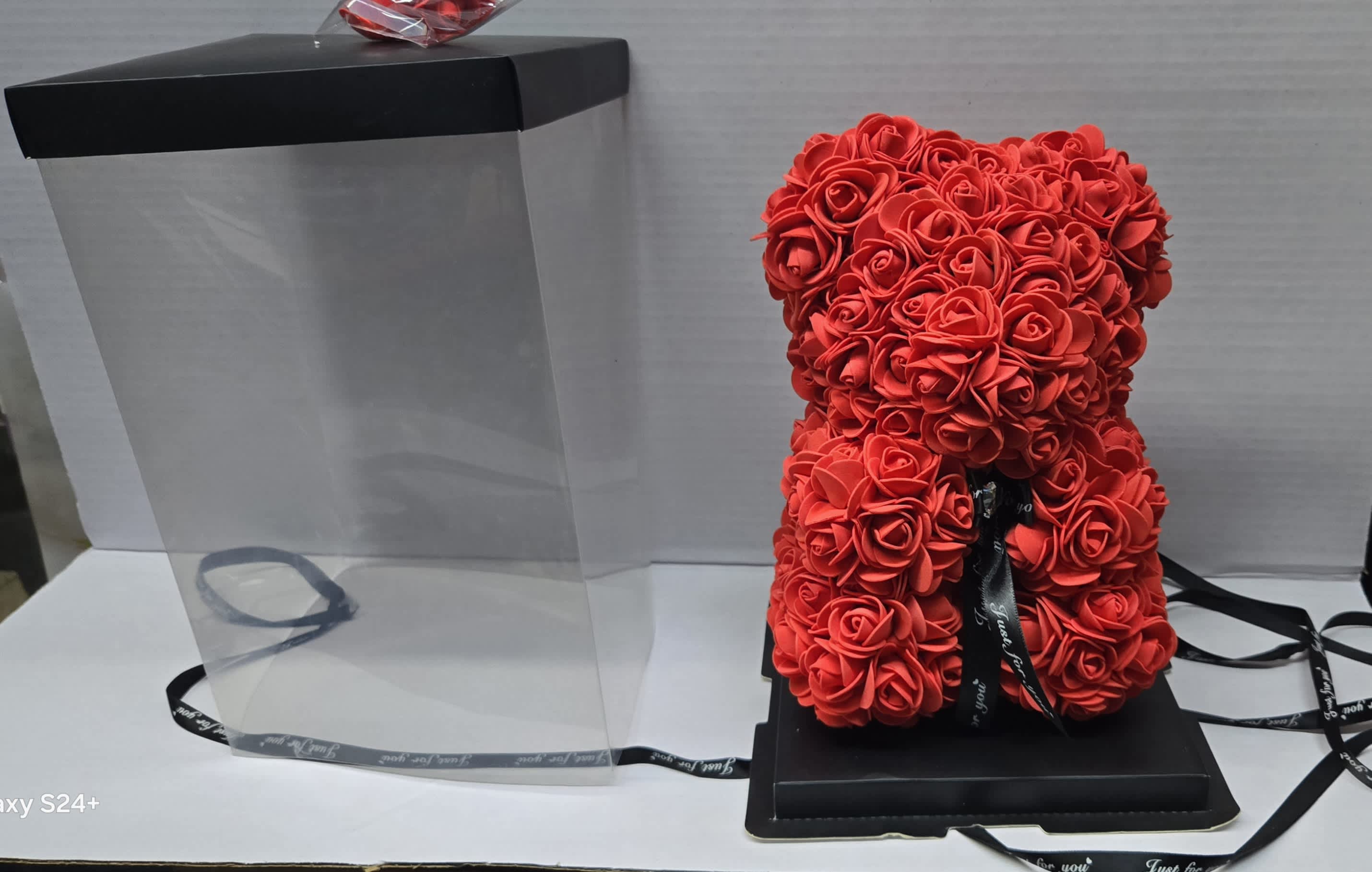 Red rose teddy bear in a clear gift box with a black lid