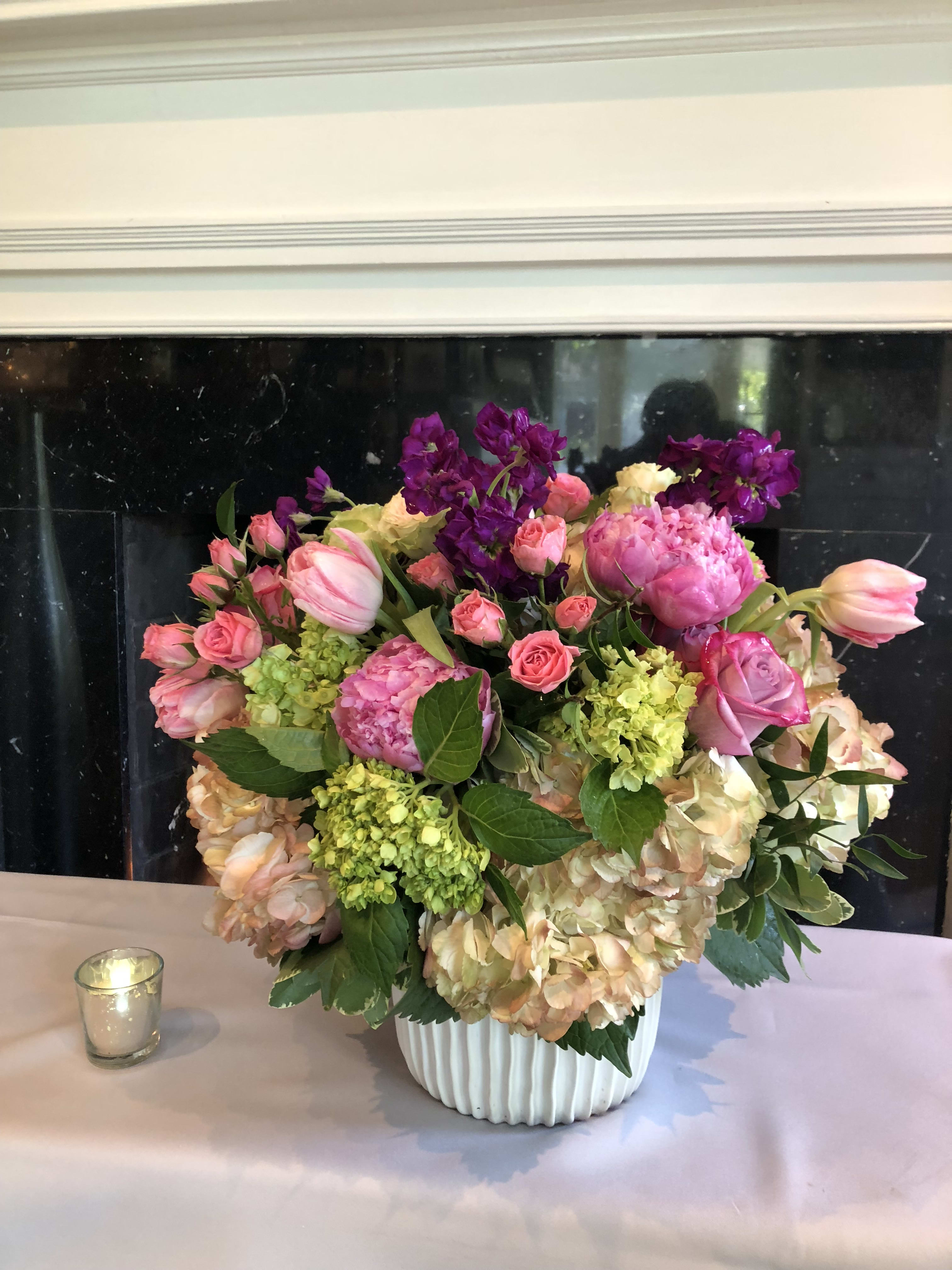 Pink and peach floral arrangement in a white vase