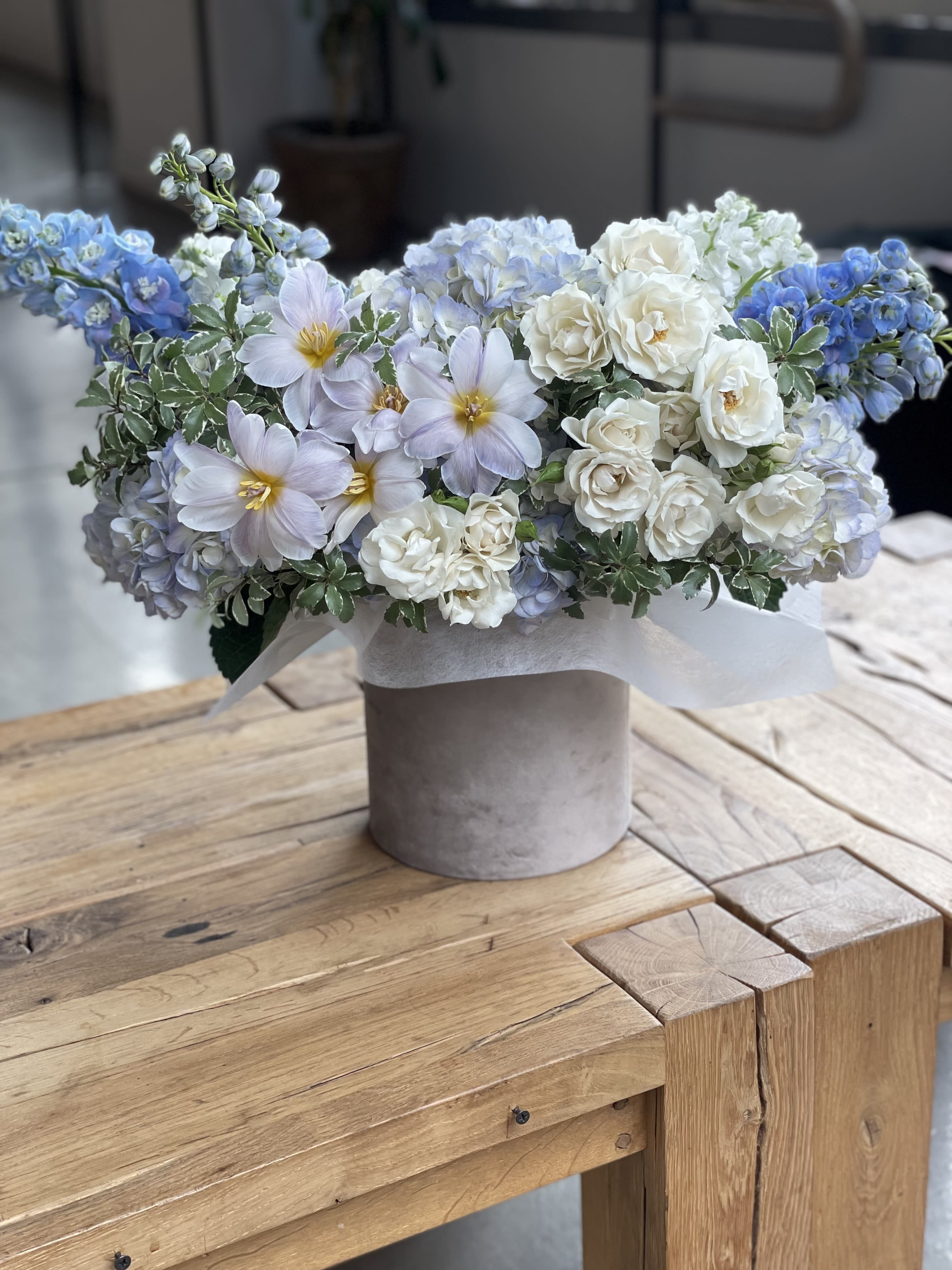 Blue and white floral arrangement in a gray vase
