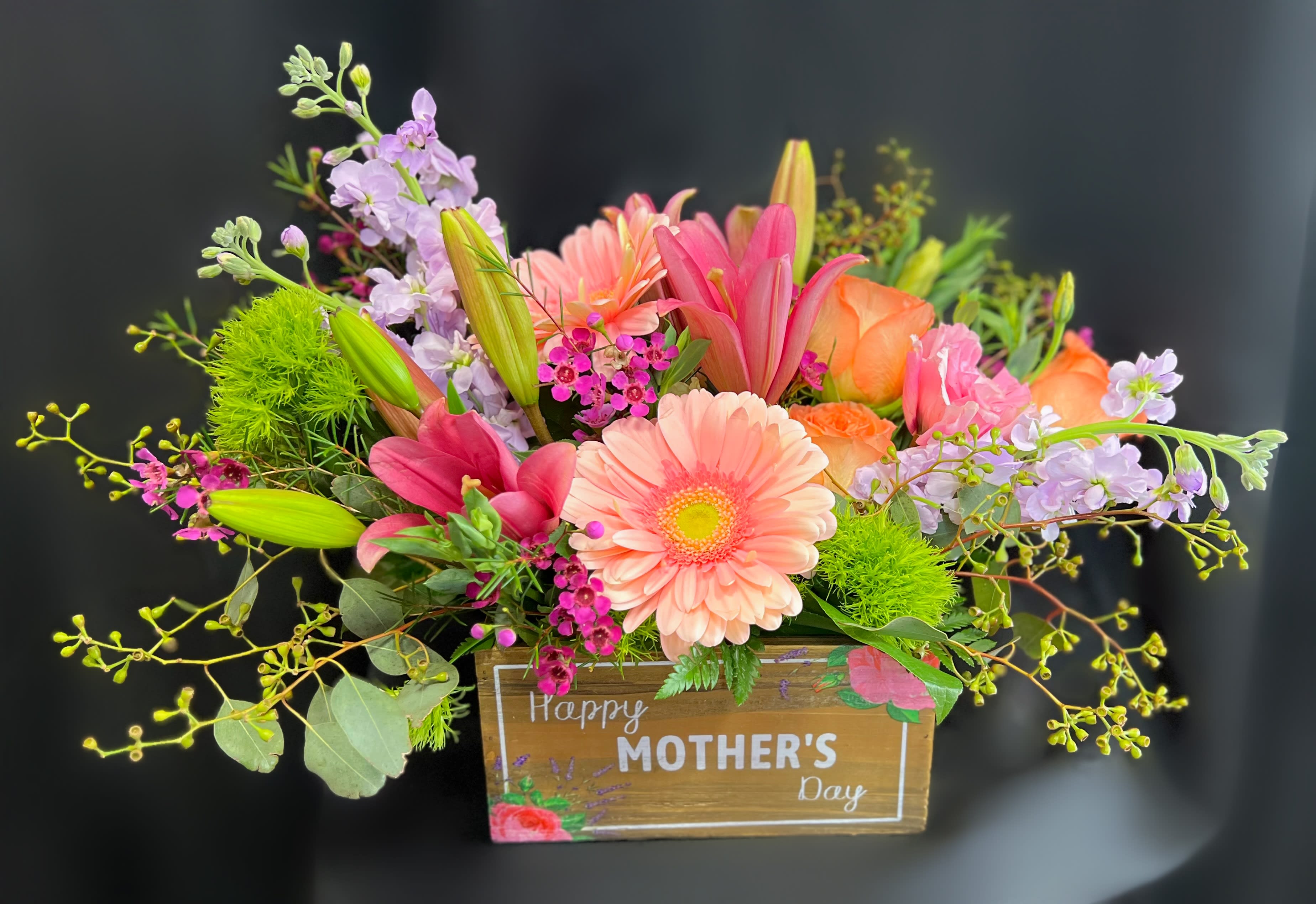 Colorful mixed flower arrangement in a wooden Mother's Day box