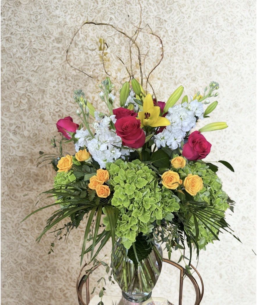 Citrus and Stem - A fresh, vibrant arrangement featuring green hydrangeas, roses, lilies and white stock, spray roses, accented with natural curly branches. 