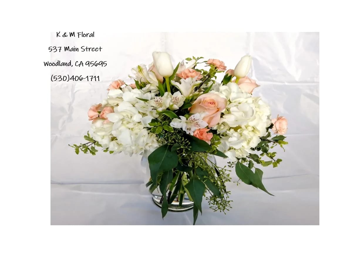 Peach Perfection - White hydrangea accented with peach roses, white tulips, peach mini carnation and white alstromeria with hints of seeded eucalyptus and italian pittosporum.  When tulips are out of season we will substitute with something gorgeous to keep the same look and feel.