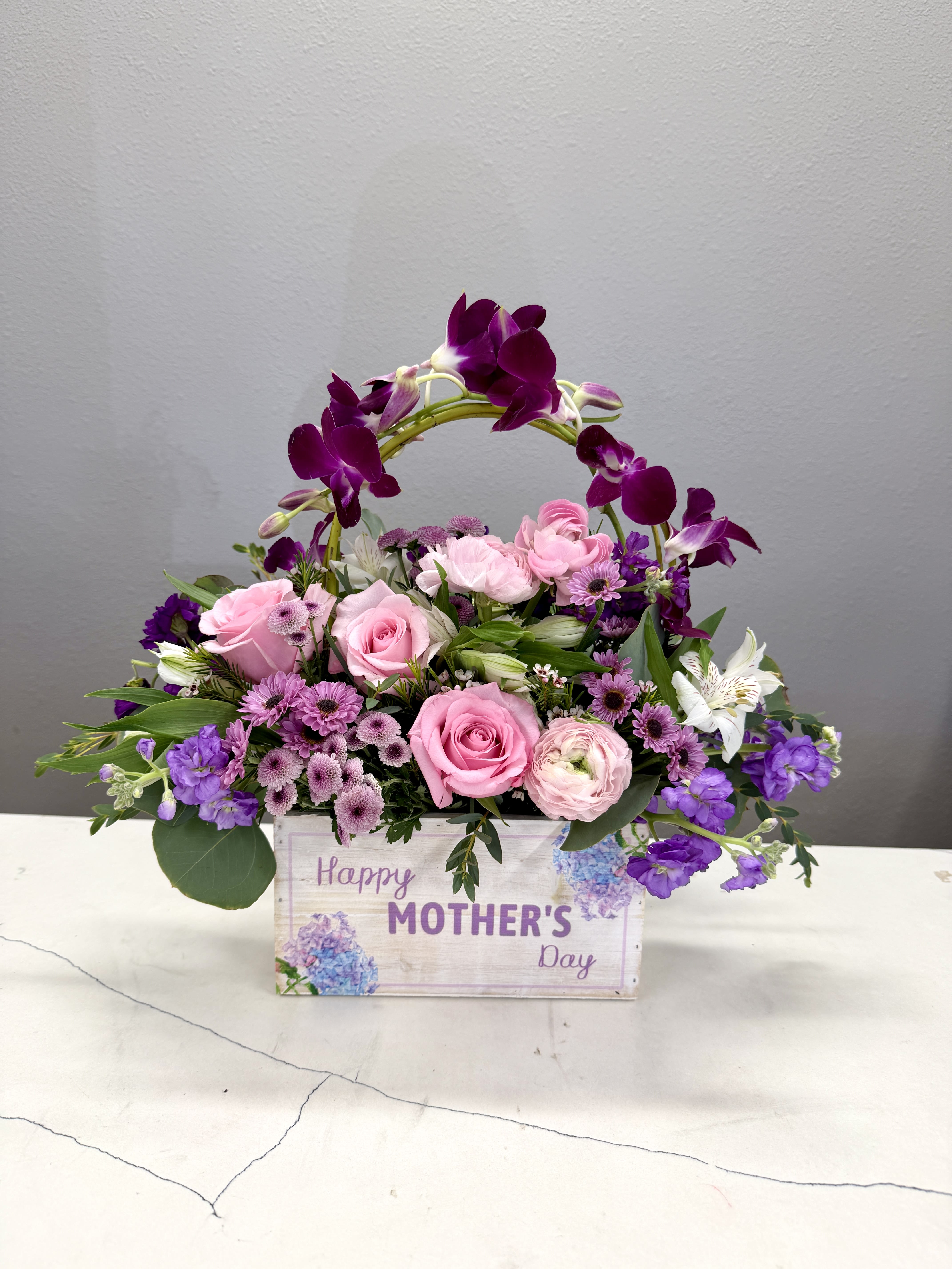 Mother’s Day Sweet Embrace - Mother’s Day Sweet Embrace is the arrangement feels like a hug in floral form—thoughtful, beautiful, and made to celebrate her. Blush pink roses and delicate ranunculus create a soft, lush base, while dendrobium orchids add elegance.