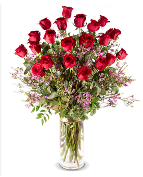 Tall bouquet of red roses in a clear glass vase