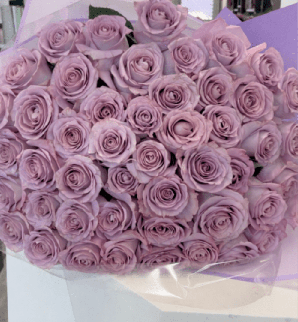 Bouquet of lavender roses wrapped in pale purple paper