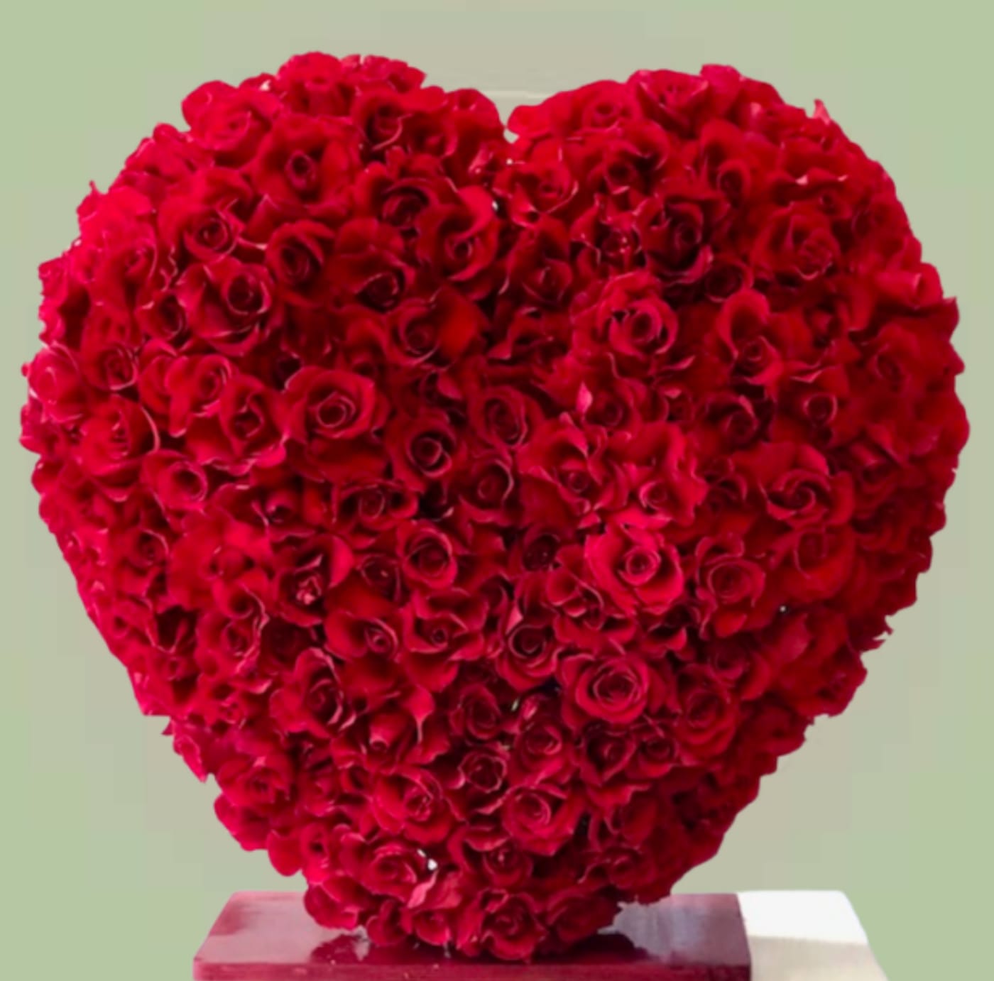 Heart-shaped arrangement of red roses on a pedestal