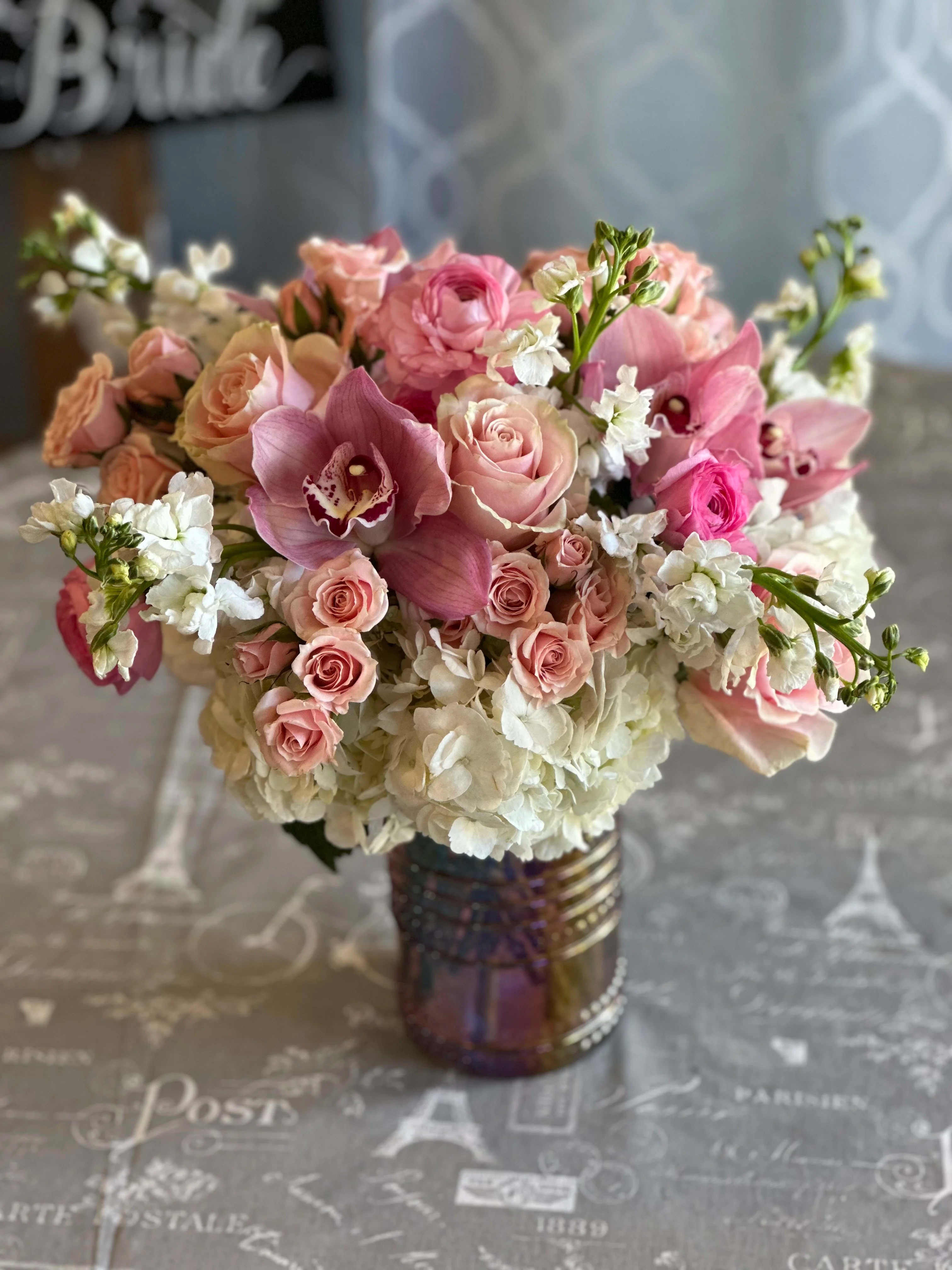 Pink roses and orchids arranged in a glass vase