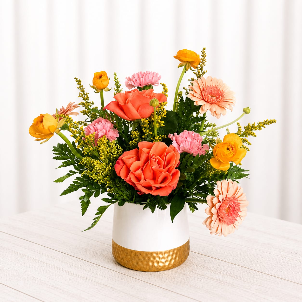 Citrus Blossom - Bright, bold, and full of personality—Citrus Blossom Pop is designed to make a statement. Featuring vibrant coral roses, cheerful yellow blooms, and soft peach accents, this arrangement is bursting with color and fresh energy. Styled in a modern white container with a gold base, it’s the perfect mix of playful and polished. Perfect for celebrations, birthdays, or sending a little sunshine someone’s way.