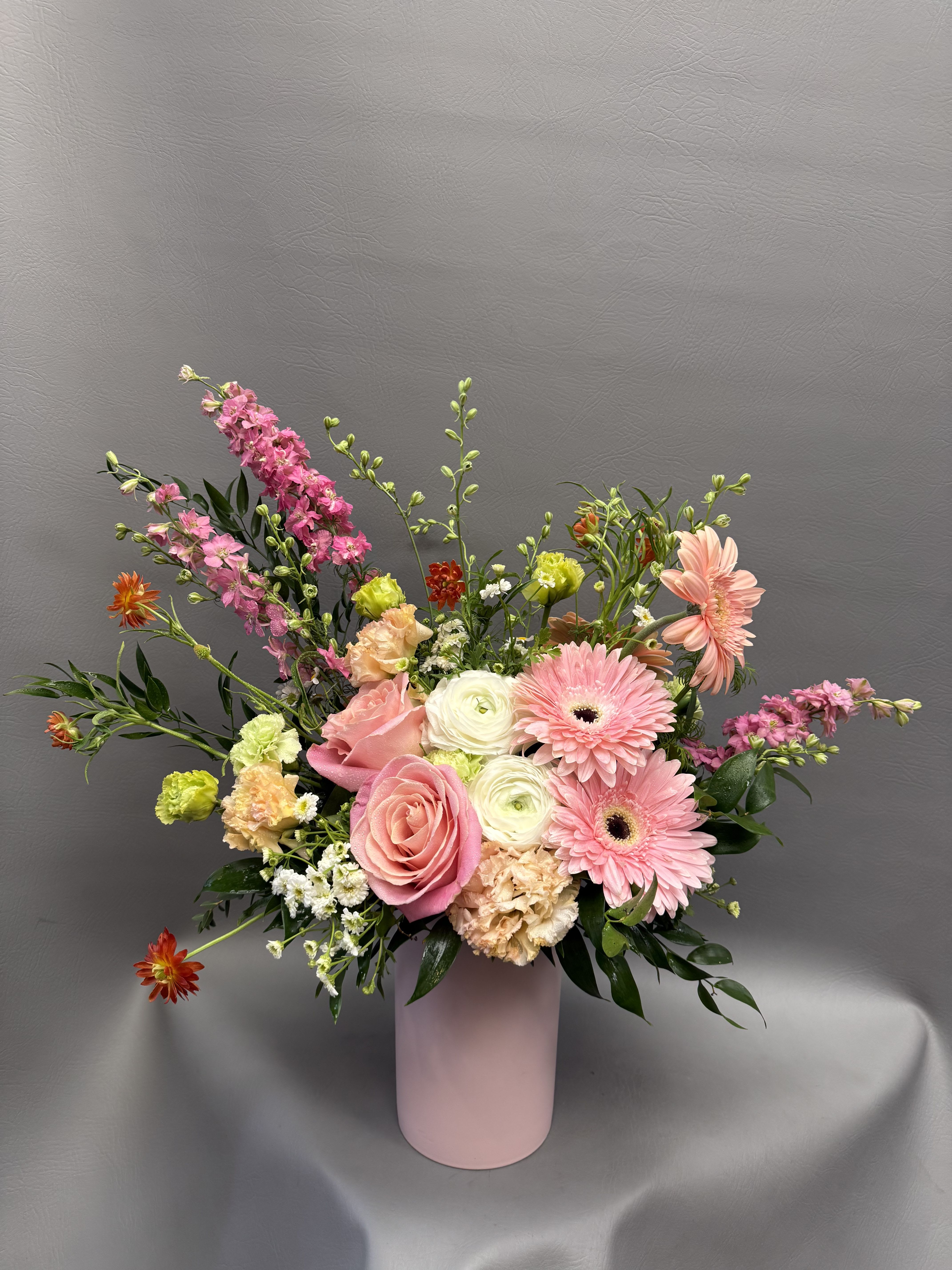 Mom’s Garden Glow - A soft and cheerful mix of blush pink, peach, and creamy blooms arranged in a modern vase. This garden-inspired design is full of texture and movement—perfect for celebrating Mom with something fresh, elegant, and full of love.