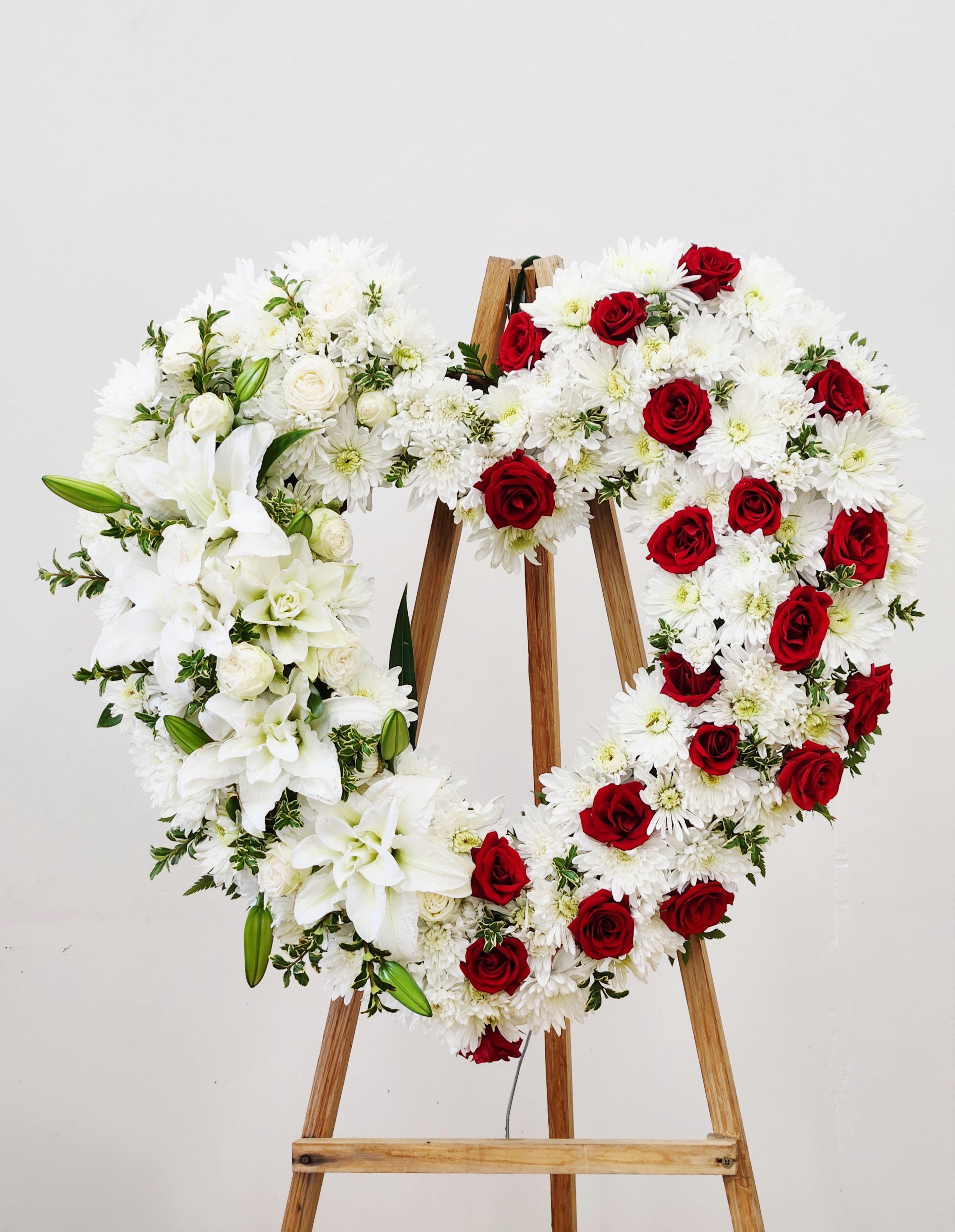 Beloved Heart Spray - An open heart-shaped standing tribute of red roses and white blooms makes an immediate, heartfelt impression - ideal as a sympathy tribute or a romantic ceremonial piece for a wedding or memorial service. The heart shape and easel presentation read as a formal, respectful display that will make the recipient or those remembering a loved one feel truly honored and seen.  