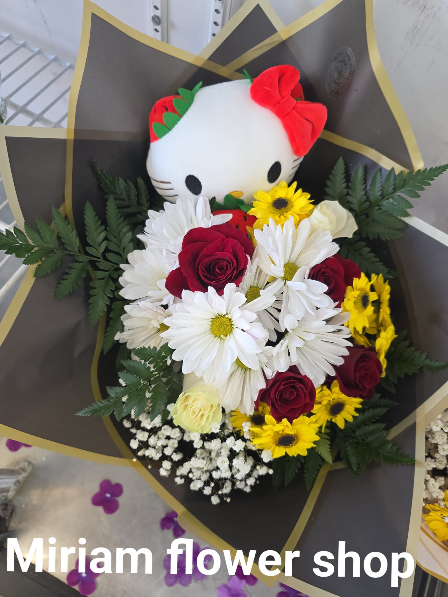 Bouquet with a Hello Kitty plush and red, white, and yellow flowers