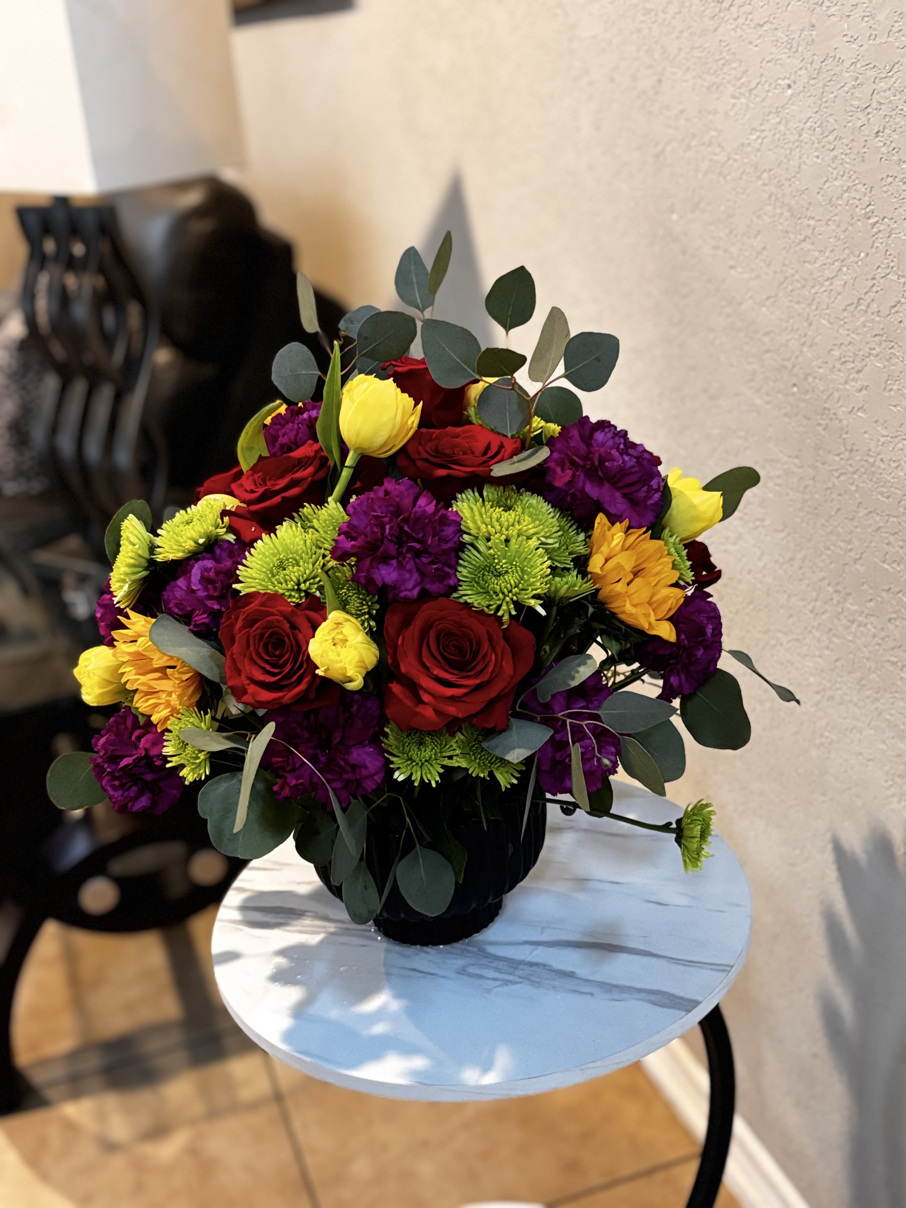 SONTERRA - Beautiful colorful flower arrangement in San Antonio featuring fresh red roses, sunflowers, green button mums, carnations, tulips, and eucalyptus in a modern black container. Designed by Snyder Flowers San Antonio, this vibrant floral design is perfect for birthdays, celebrations, and special occasions.   Same-day flower delivery in San Antonio  Fresh premium flowers and elegant floral designs  Serving Stone Oak, Medical Center, Alamo Heights, Cibolo, and surrounding areas